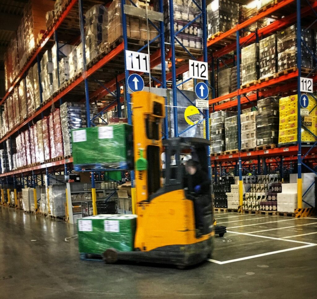 Warehouse racking and forklift where shipper Scope 3 transport emissions begin